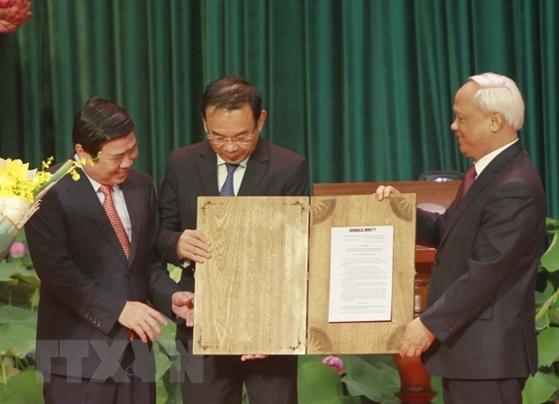 Vice NA Chairman Uong Chu Luu (R) hands over NA Standing Committee’s resolution on organising administrative units at the district and commune levels and establishing Thu Duc city to HCM City (Source: VNA)  