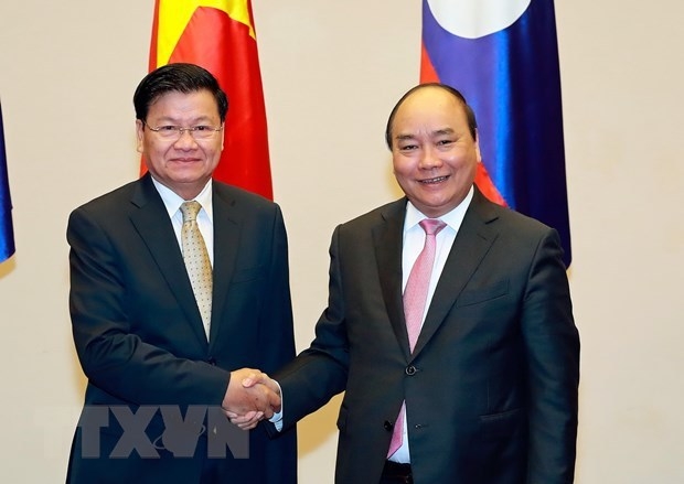Prime minister nguyen xuan phuc (r) and lao prime thongloun sisoulith (photo: vna)