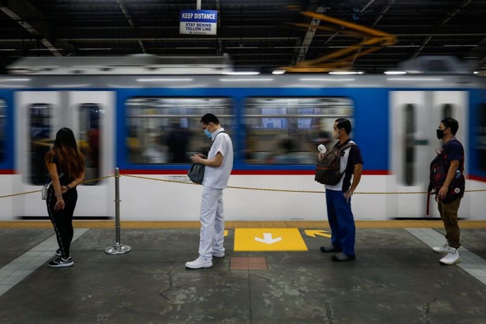 Passengers wearing face masks for protection against the coronavirus disease (COVID-19) maintain social distancing while queueing to ride a train in Quezon City, Metro Manila, Philippines, July 21, 2020. 