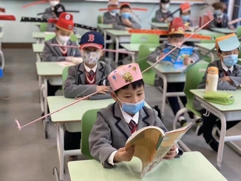 chinese primary students return schools with self made distancing hats