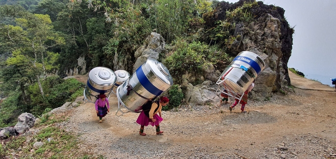 impressive images of upland women carrying giant water tank on back