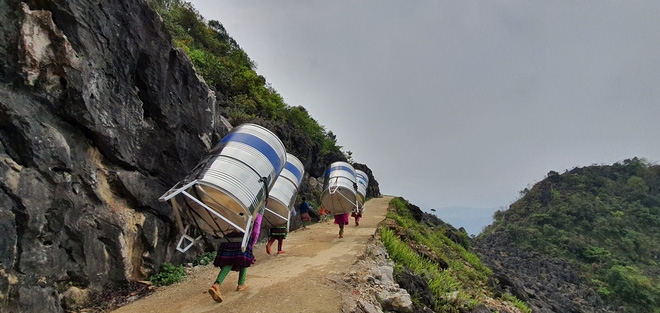 impressive images of upland women carrying giant water tank on back