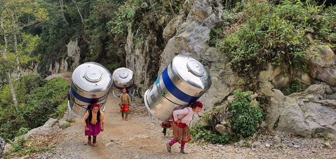 impressive images of upland women carrying giant water tank on back