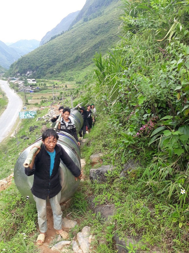 impressive images of upland women carrying giant water tank on back