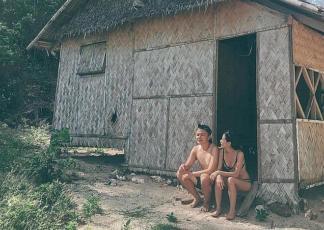 The couple sitting at the door of a cottage 