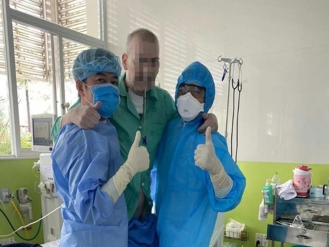 The British pilot takes a picture with two doctors at Cho Ray Hospital 