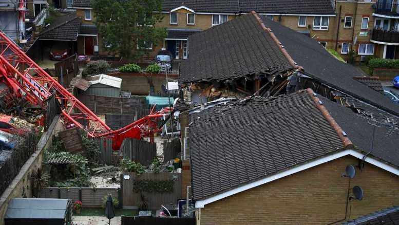 A 20-metre long crane fell on two houses in east London on Wednesday afternoon, killing one woman and injuring four other people.  