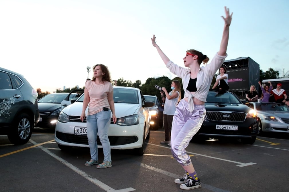 Fans dance by a car during a performance of the rock ban The Hatters in Moscow, Russia