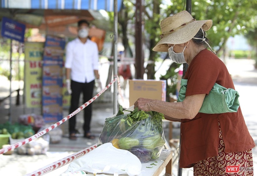 A lady takes a bagful of foods from the zero dong food store 