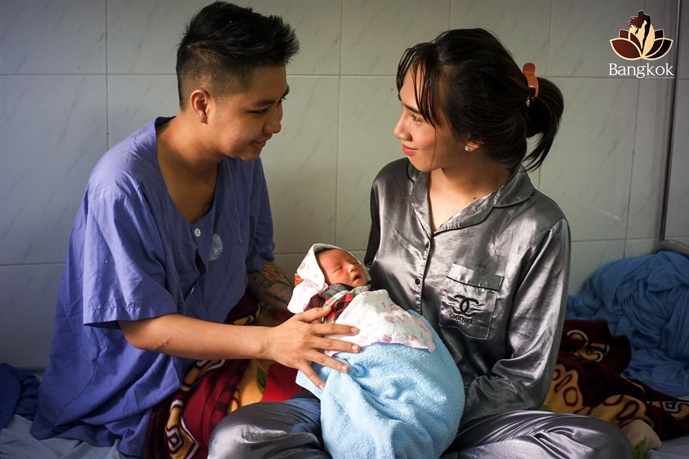 Minh Khang (L) and his wife holding the newborn baby