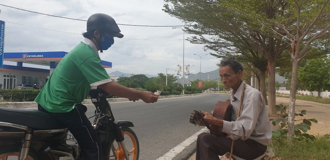 A passer-by giving Minh some money 