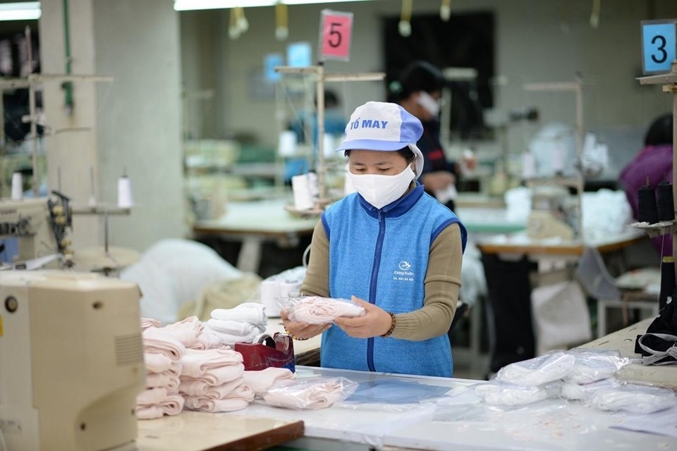 An assembly-lined worker packaging face masks in Vietnam