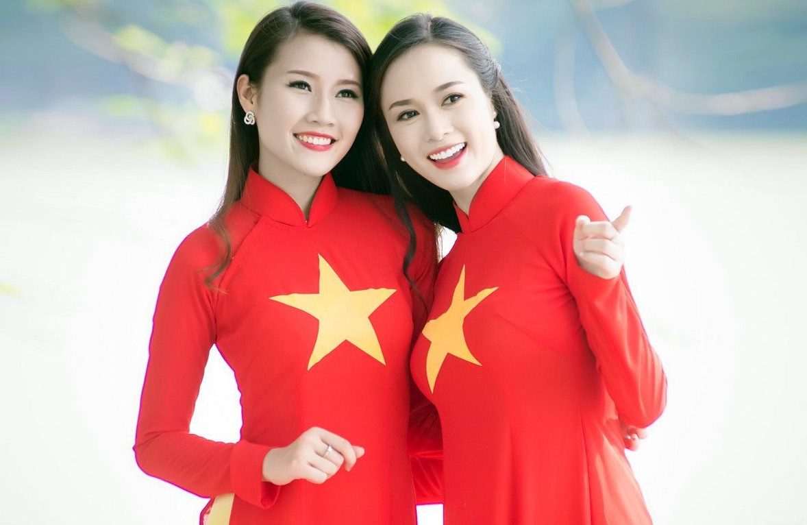 Two women wearing Ao Dai in the colors and images of Vietnam's national flag (Photo: Redsvn) 