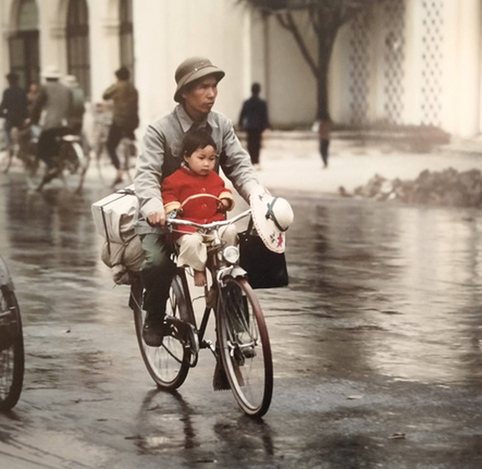 A father carrying his daughter on a bicycle (Photo courtesy of Thomas Billhardt/ via Zing News) 