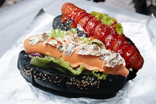 Charcoal-black bread with gold-plated hotdog in HCMC
