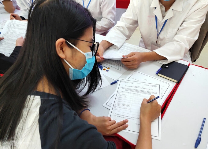 First Vietnamese girl signing for voluntary form for the phase one of Nanocovax's human trials  (Photo: Dan Tri) 