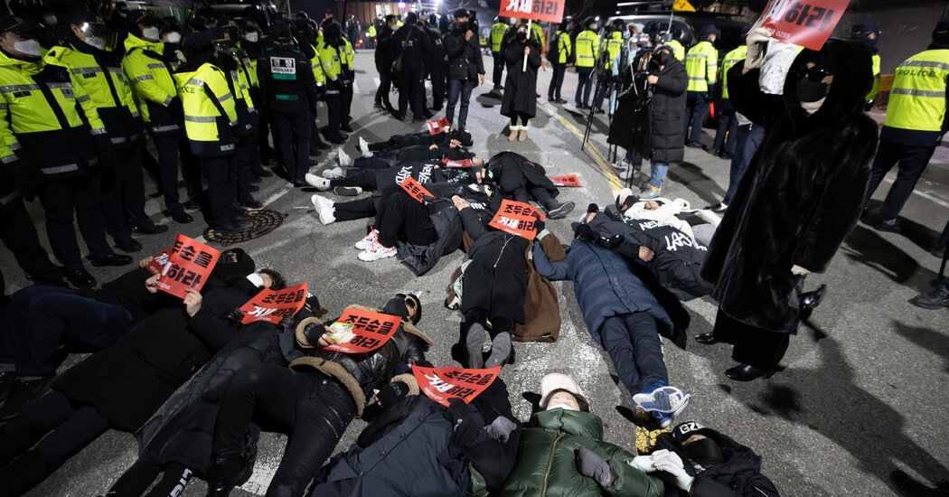 Some protesters lay on the pavement, holding signs and shouting slogans (Photo: NY Times)  