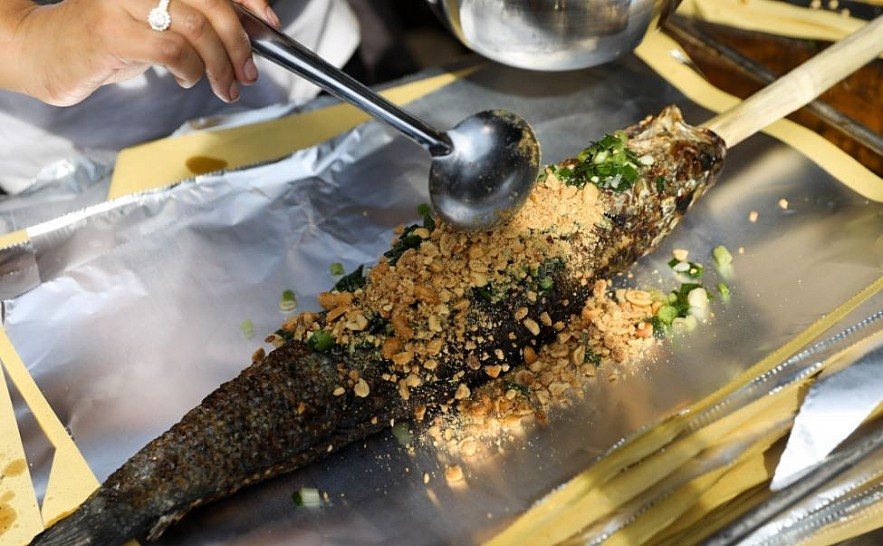 Explaining Vietnamese Culture: Why People Buy Grilled Snakehead in God of Wealth's Day?