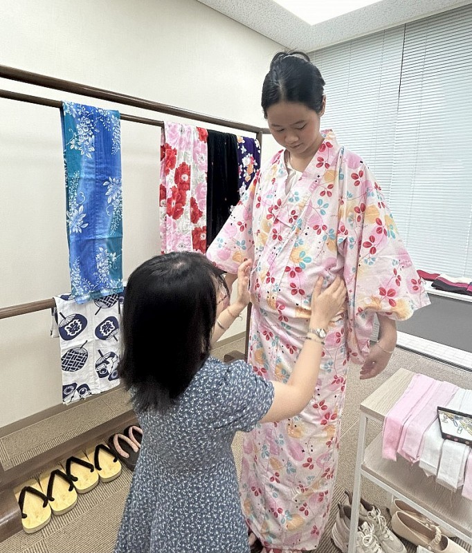 Staff at the Japanese Cultural Information Center guide visitors on how to wear Yukata. (Photo: Bach Duong)