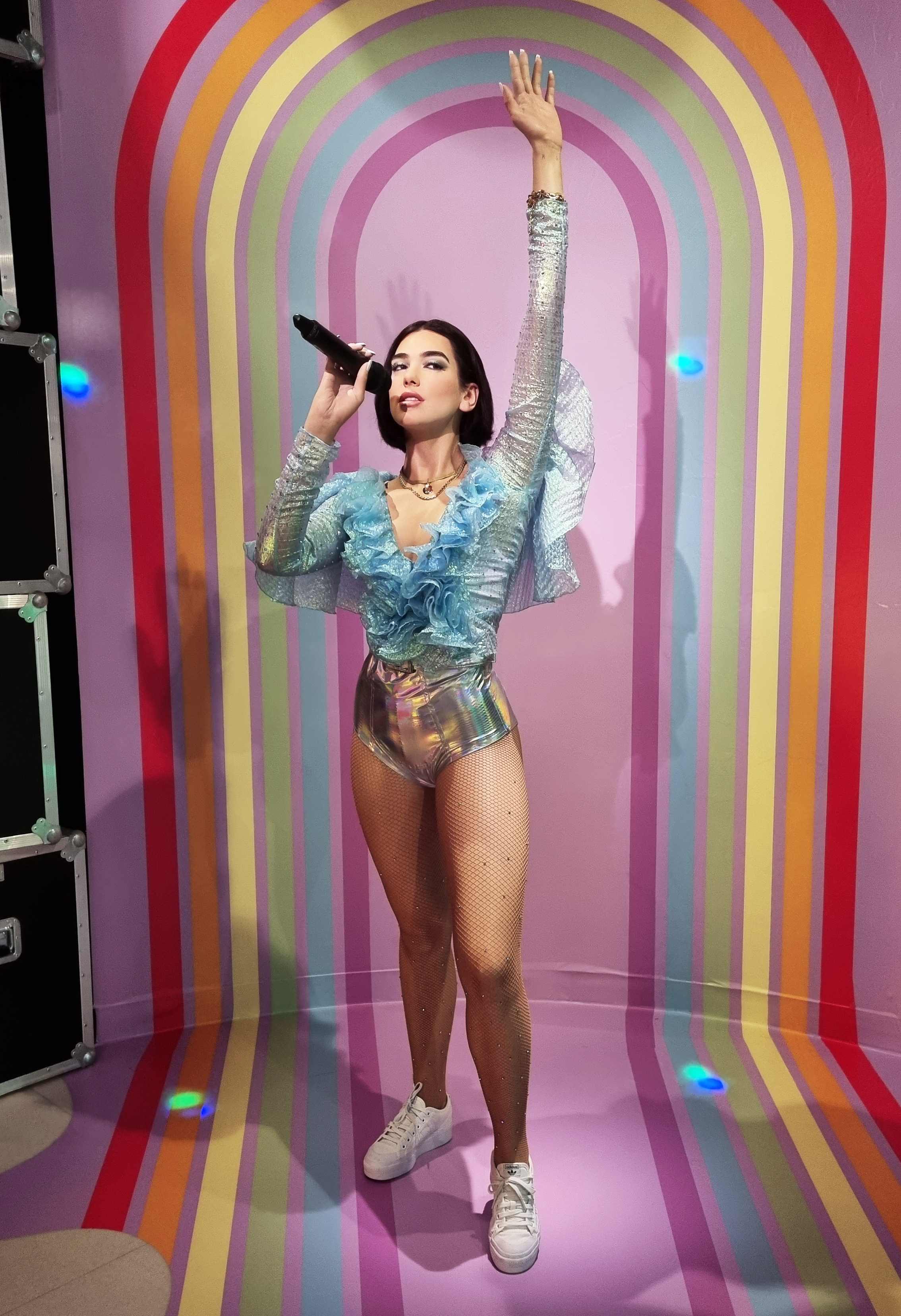 Dua Lipa’s fifth wax figure is dressed in a blue iridescent ruffle top and holographic pants.
