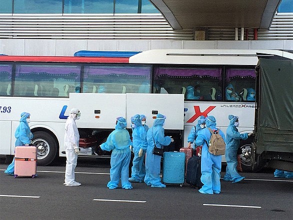 This file photo shows Vietnamese repatriates getting on a bus after arriving at Cam Ranh International Airport in Khanh Hoa Province, Vietnam. Photo: Phan Sau / Tuoi Tre