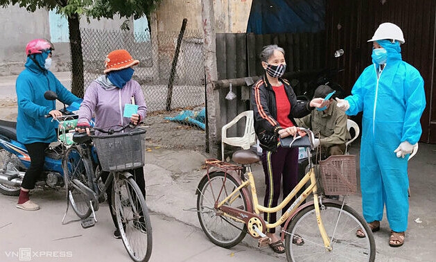 Women in Hai Duong Province receive coupons for going to the market amid a Covid-19 outbreak on February 17, 2021. Photo VnExpress