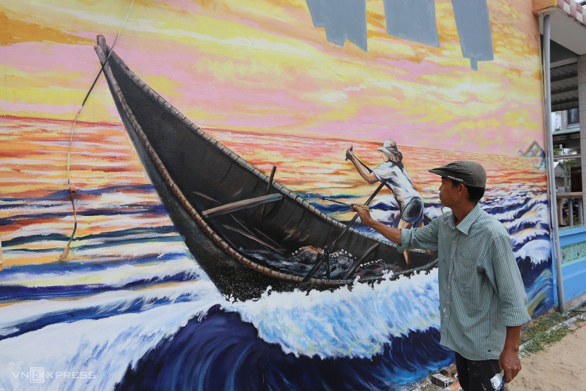 Artist Pham Dinh Hai is drawing a mural with 15m in length and 5m in width on the wall of a local house. His painting features coastal village’s residents riding boats to catch fish.