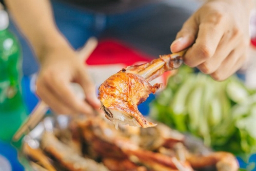 Using hands to eat the grilled chickens is the best way to enjoy the dish. Photo VnExpress