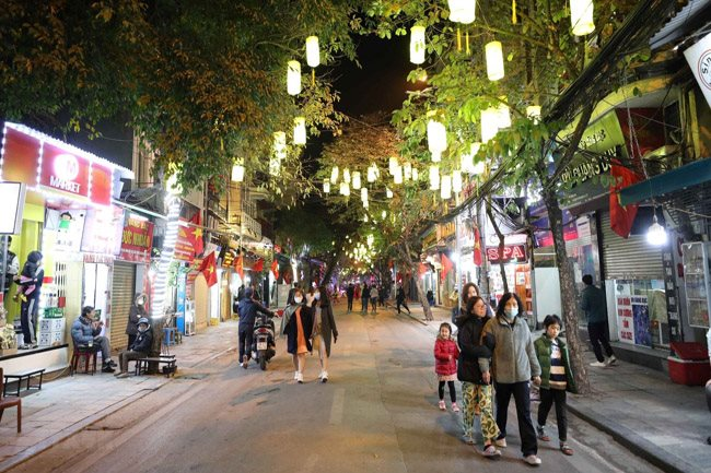 Local residents stroll along a pedestrian street in Hanoi. The capital city will hold a festival to promote its tourism and culinary culture from April 16 to 18 – PHOTO: VNA