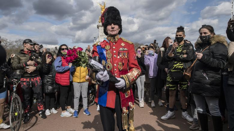 A man put flowers outside London's Buckingham Palace (Photo: CNN) 