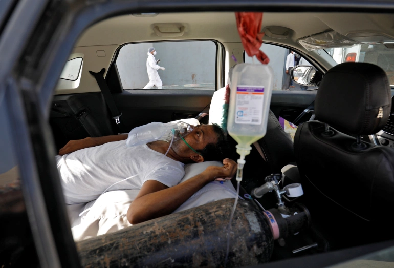 A patient with breathing problems is seen inside a car while waiting to enter a COVID-19 hospital in Ahmedabad [Amit Dave/Reuters]