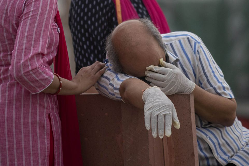 A man reacts before the cremation of his relative, who died from the coronavirus disease (COVID-19), on the banks of the river Ganges at Garhmukteshwar in the northern state of Uttar Pradesh, India, May 6, 2021. REUTERS/Danish Siddiqui