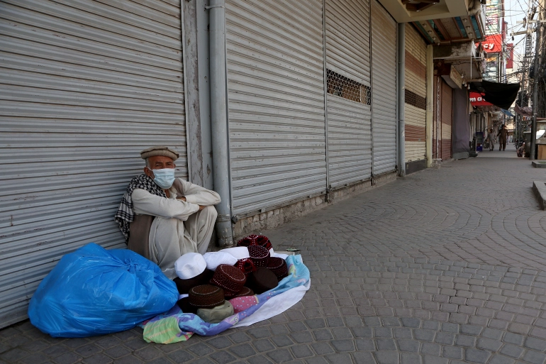 A street vendor waits for customers at a market closed as the government announced new restrictions for the COVID-19 measures, in Peshawar, Pakistan [Muhammad Sajjad/AP]