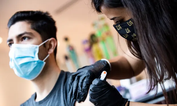 A patient is vaccinated against Covid-19 at an event organized by the Los Angeles Football Club in California. Photograph: Étienne Laurent/EPA