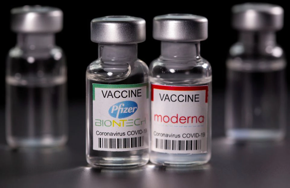 Vials with Pfizer-BioNTech and Moderna coronavirus disease (COVID-19) vaccine labels are seen in this illustration picture taken March 19, 2021. REUTERS/Dado Ruvic/File Photo