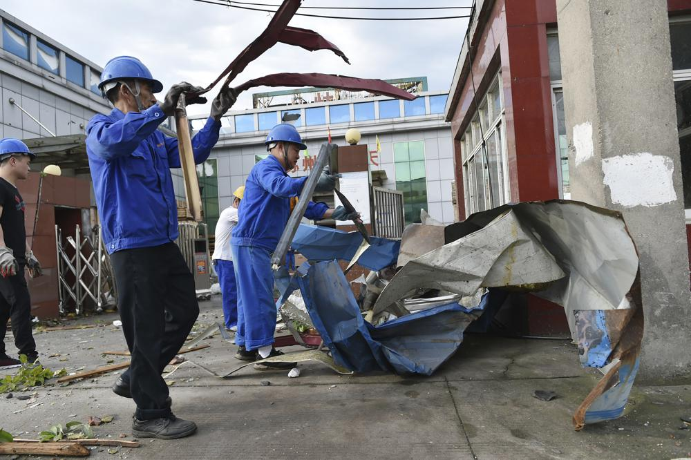 Workers clear debris at a factory that was damaged by a reported tornado in Shengze township in Suzhou in eastern China's Jiangsu Province, Saturday, May 15, 2021. Two tornadoes killed several people in central and eastern China and left hundreds of others injured, officials and state media reported Saturday. (Chinatopix via AP)