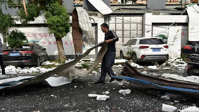 A man cleans up damage after a tornado hit the city of Suzhou in China's eastern Jiangsu province province on May 15, 2021. (Photo: AFP)