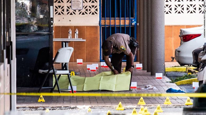 A Miami-Dade officer covers a body outside a club that was rented out for a concert. (Photo: CNN) 