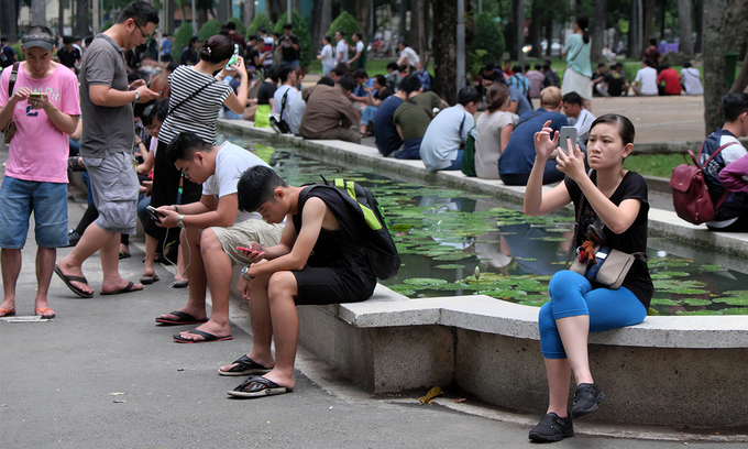 People play game on their smartphones in Ho Chi Minh City. Photo by Shutterstock/xuanhuongho.