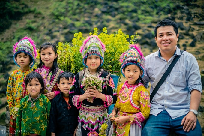 Quy taking pictures with children at Tham Ma Pass. Photo: VnExpress 