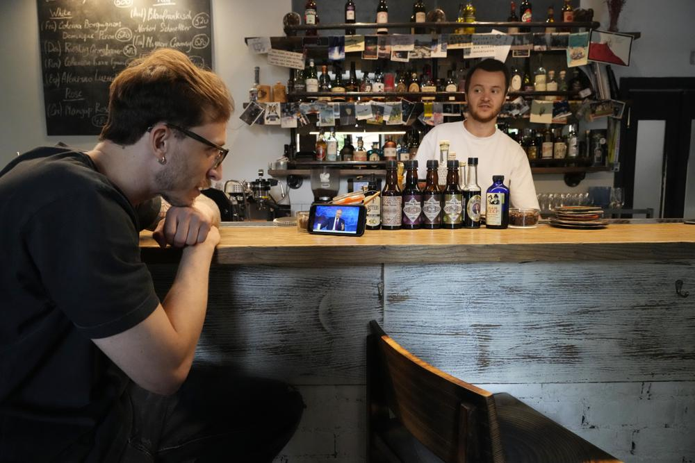 A bartender watches his smartphone showing a live stream of Russian President Vladimir Putin's annual televised call-in show, in a bar in Moscow, Russia, Wednesday, June 30, 2021.  Photo: AP 