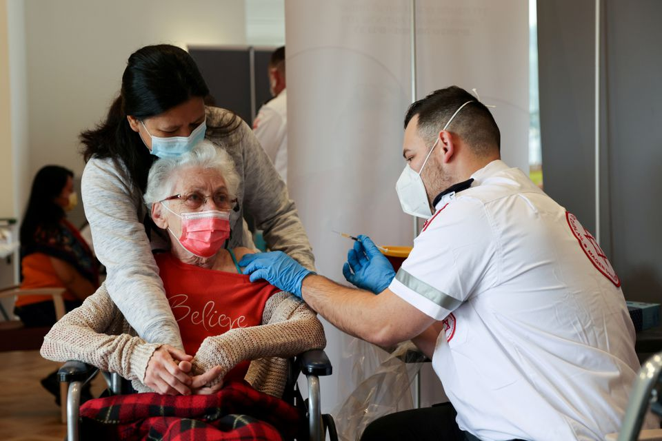 An elderly woman receives a booster shot of her vaccination against the coronavirus disease (COVID-19) at an assisted living facility, in Netanya, Israel January 19, 2021. REUTERS/Ronen Zvulun/File Photo