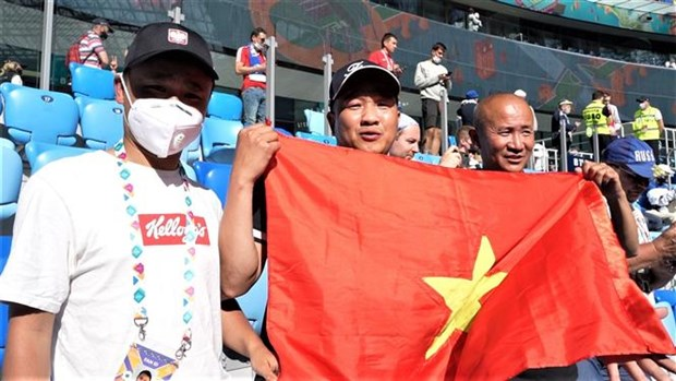 Hoang Van Phu (middle) and Nguyen Duc Vuong (right) holding Vietnam's flag at Vladivostok. Photo: VNA