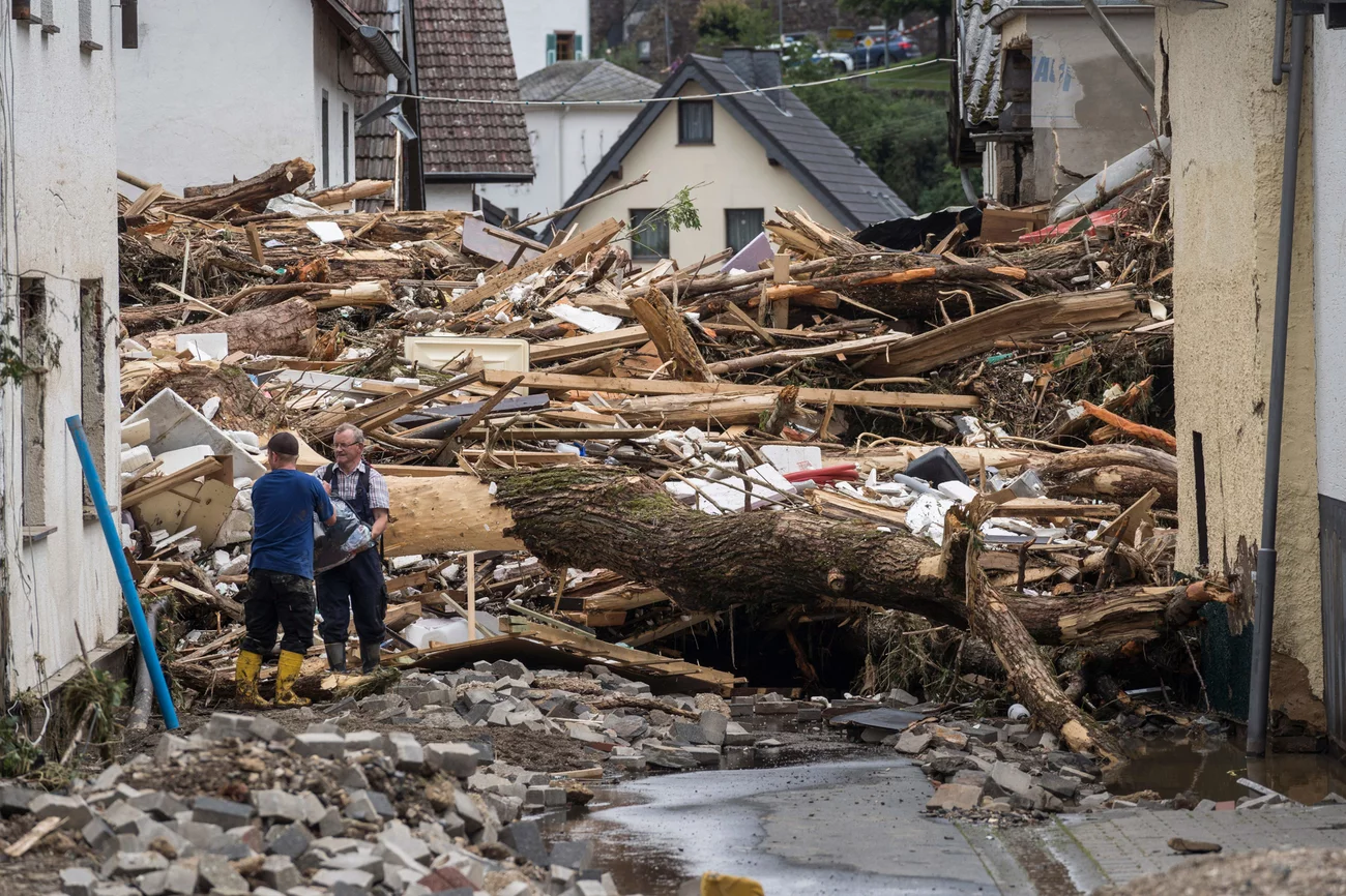 Two men try to secure goods near houses destroyed by floods Thursday in Schuld. Bernd Lauter/AFP via Getty Images