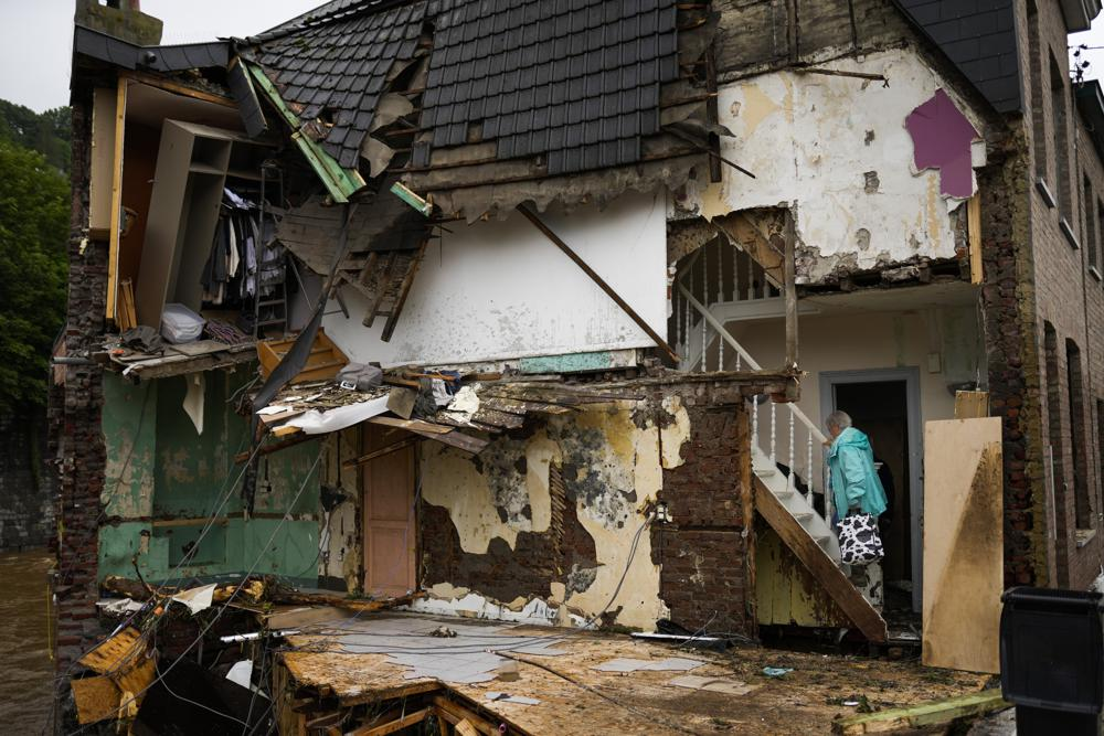 A woman walks up the stairs in her damaged house after flooding in Ensival, Vervier, Belgium, Friday July 16, 2021.  Photo: AP 