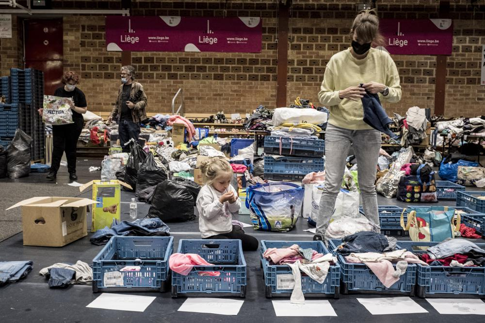 A woman sorts through clothing in a shelter for residents after flooding in Angleur, Province of Liege, Belgium, Friday July 16, 2021. Photo: AP 