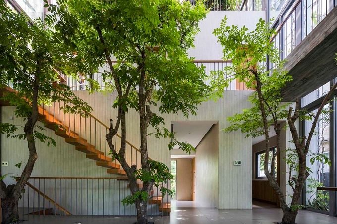 In a space created by a block that cuts through three floors, the living room blends with the greenery outside. 