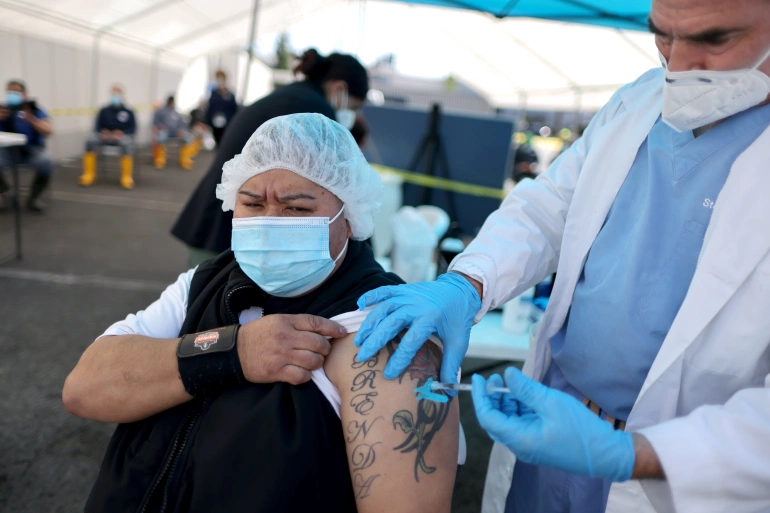 An essential worker getting a vaccination at a mobile drive for essential food processing workers in Vernon, Los Angeles, California, on March 17, 2021 [Lucy Nicholson/Reuters]