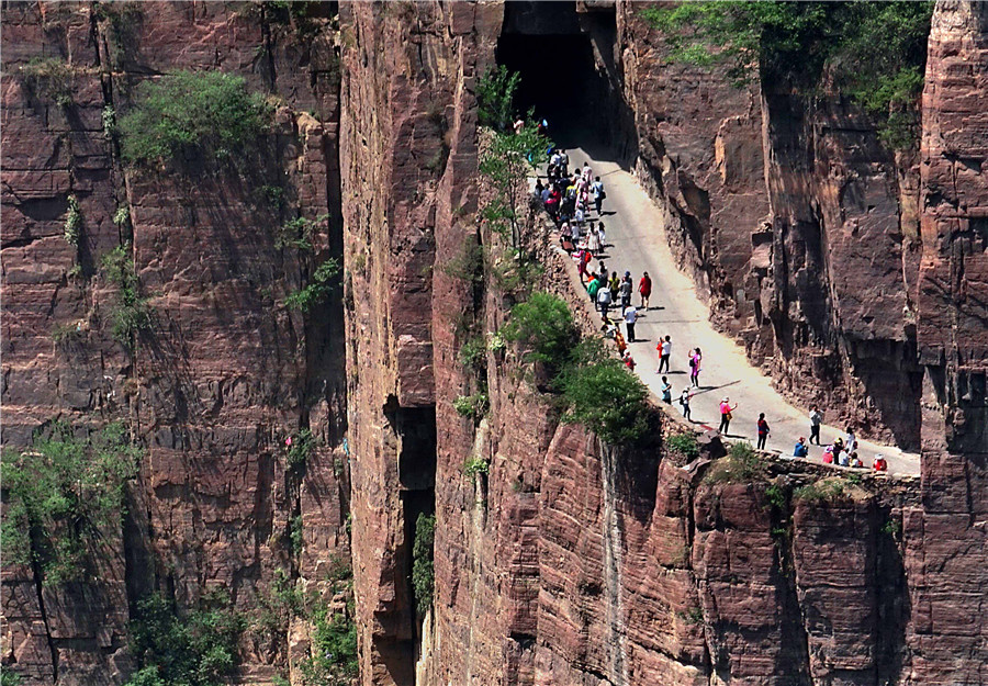 Tourists visit a section of the road that links to Guoliang village in Huixian county, Henan province. The road winds through the Taihang Mountains. LI AN/XINHUA