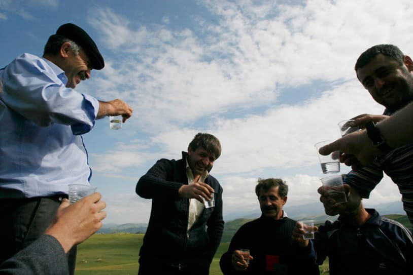 Men pause for a glass of vodka. | (REUTERS/Thomas Peter)
